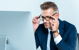 glasses to match your needs | photo of corporate guy siting in formt of large screen computer