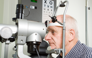 dilated eye exam | photo of oldr gentleman getting an eye exam