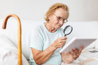 Low Vision | photo of older woman using a magnifying glass