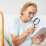 Low Vision | photo of older woman using a magnifying glass